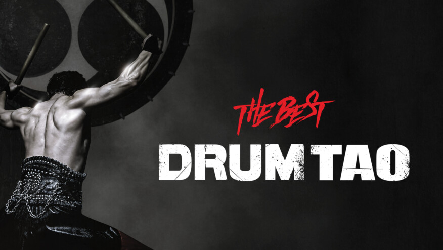 The back of a man with raised hands holding drumsticks. Text reads 