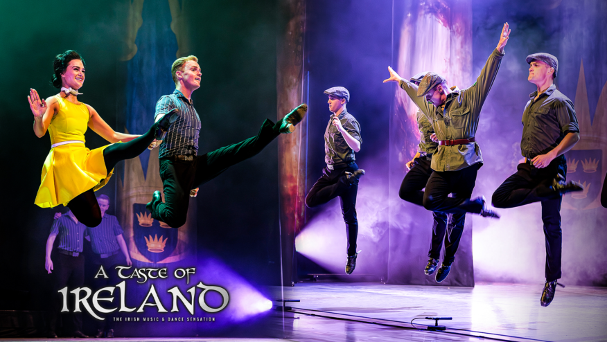 Six dancers leap into the air on stage. Text reads, 